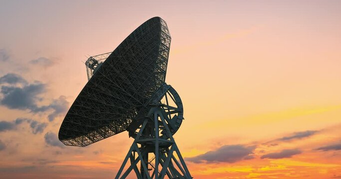 Astronomical radio telescope and beautiful sky clouds at sunset. 4K time lapse footage.