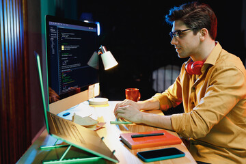 Side profile view young professional freelancer software engineer IT specialist man in shirt work...