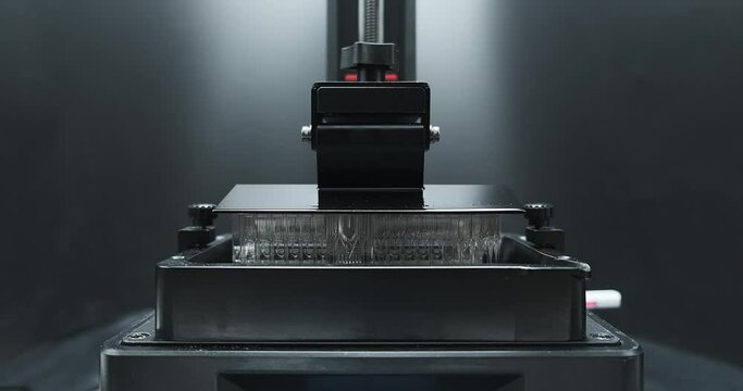 Front view of Resin MSLA3D Printer moving up and down during printing object.