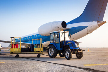 Loading luggage on the plane. Transportation of baggage in trailers to the aircraft