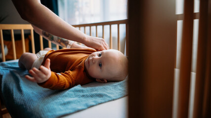 Mom changing baby diaper. 5 months Toddler. Cover photo