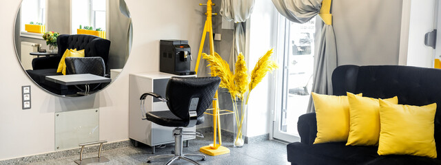 Modern small bright hair and beauty salon in black and yellow colors with gray walls and floor and...