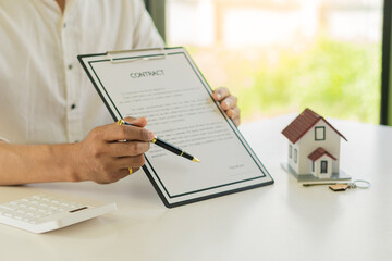 Businessman, contract signing or accountant working on financial investments. using a calculator financial documents analyze the report Real estate and home loan insurance