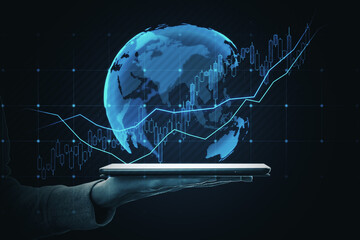 Close up of hand holding tablet with global candlestick forex chart on dark background. Trade,...