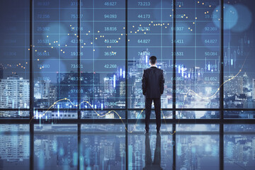 Back view of businessman standing in dark office interior with big data index, forex chart and city view. Double exposure.