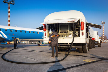 Aircraft refueling with a high pressure tanker. A passenger jet is being refueled from a supply...