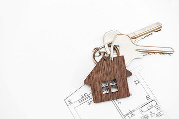 House key on a pendant in the shape of a house. Real estate concept. flat lay