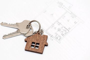 Real estate agent concept. Keys to a new house with a project on a white background.