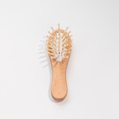 Wooden mini bamboo hair brush for travel, beard or kids on white background. Small pocket brush. Top view, copy space