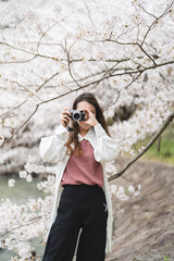 桜の写真を撮るカメラ女子