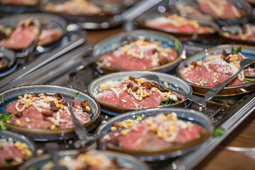 Mini carpaccio appetizers on plates during a walking diner