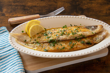 baked fish with lemon and herbs in dish