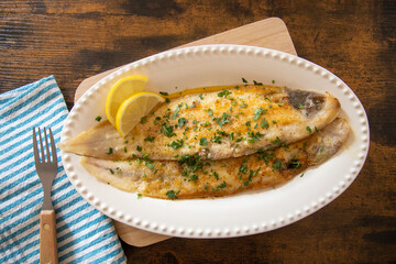 baked fish with lemon and herbs in dish