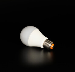 Economical LED light bulb with reflection on a black background