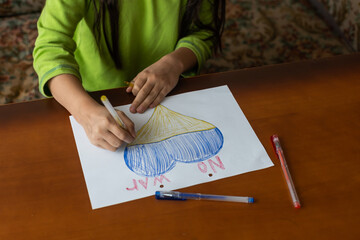 children's drawing, flags of ukraine are drawn on a sheet, children's hands hold a heart made, war...