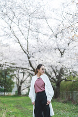 桜の花を見る眼鏡をかけた女性