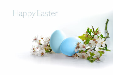 Two blue eggs and a branch of wild flowers on a white background, text Happy Easter, seasonal holiday greeting card, copy space, selected focus