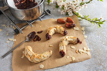 Baking healthy almond crescent cookies from almonds, oat flakes and dates with dark chocolate,...