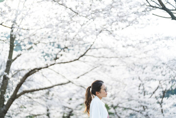 桜の花を見る眼鏡をかけた女性