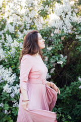 beautiful woman with a bouquet of lilac flowers in spring