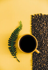 coffee background. coffee mug. copy space with coffee beans. coffee beans on the dining table. closeup of coffee beans. orange mug with black coffee