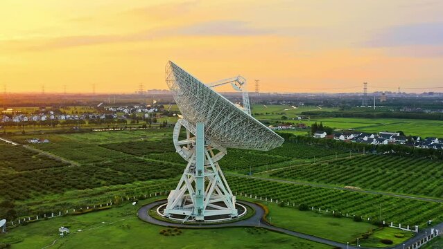 Aerial footage of astronomical radio telescope and beautiful sky clouds at sunset. Radio telescopes are used in science for space observation and distant objects exploring. Drone surround shooting.