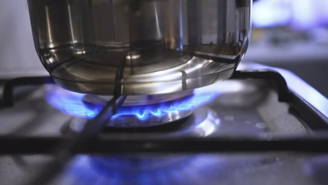 saucepan in a fire on the burner of the gas stove. A stove uses combustible or natural gas from the city gas network or liquefied gas as fuel. the energy crisis and rising energy prices. slow motion 