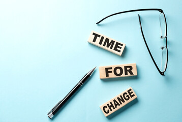 Text TIME FOR CHANGE concept on wooden block on the blue background