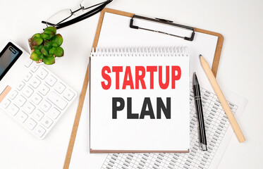 Office desk table with paper sheet, notepad ,chart and calculator. Top view STARTUP PLAN