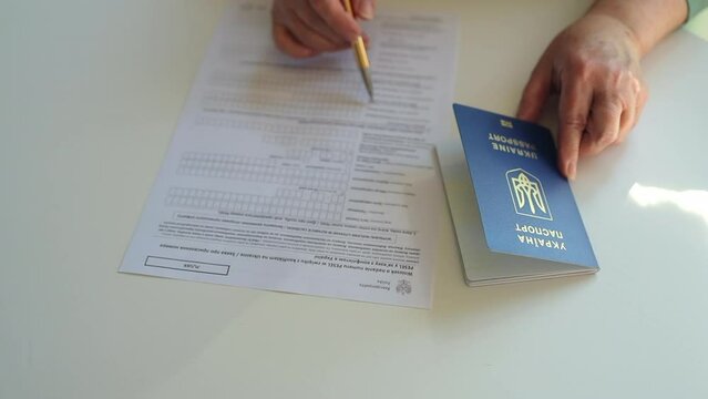 PESEL. National identification number in Poland. Polish ID. Official personal document.Woman hand write with a pen in PESEL document on white table