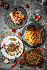 Set Georgian dishes chakapuli, shish kebab and meat chop steak with walnut sauce on a dark background. vertical image. top view. place for text