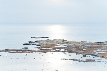 Fototapeta premium A small fishing boat on the beach in Jaffa, on a foggy day. Concept for peace, quiet and serenity. High key photography. High quality photo