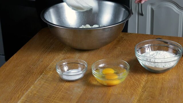 The hands of a young chef girl add vanillin, sugar, flour, eggs to the curd and mix. High quality 4k footage