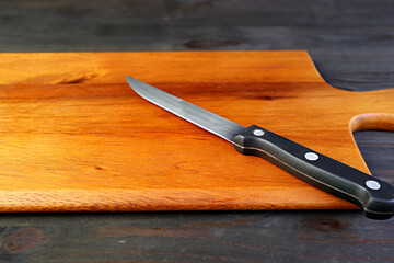 A kitchen knife on wooden cutting board for the concept of COOKING