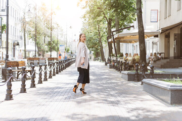 casual young woman walking along a city street.