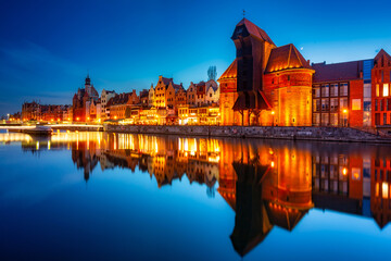 Historic port crane in Gdansk reflected in the Motlawa river at dusk, Poland