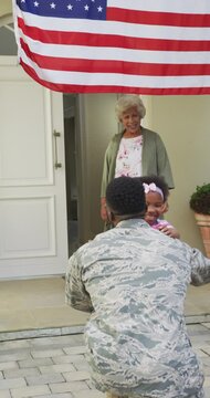 Vertical video of happy african american daughter and grandmother with soldier father returning home