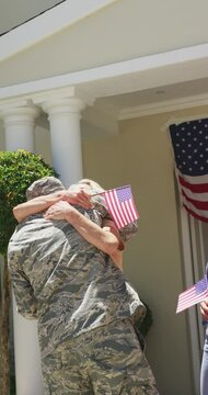 Vertical video of happy caucasian senior parents and wife greeting soldier husband returning home