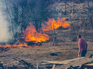 The man extinguishes the fire alone. Seasonal ecological catastrophe of burning