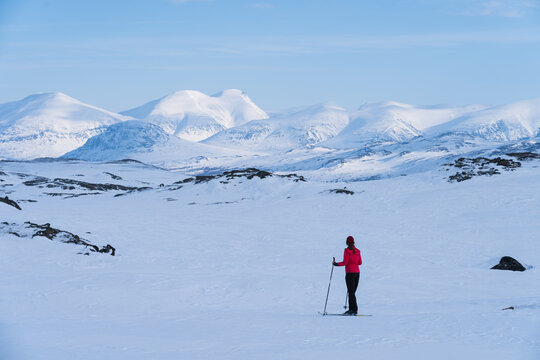 Female cross country skier with pulka (sled) in the snow in Lapland, Sweden.