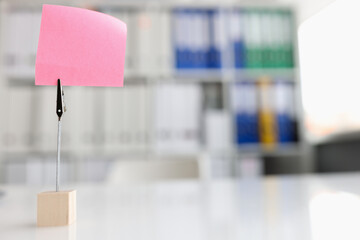Pink blank note sticker on desk in office closeup