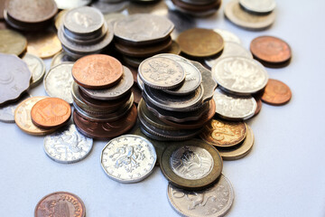 Scattered coins of different countries and stacks of coins with selective focus