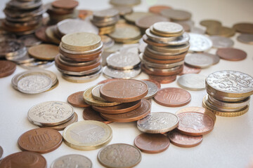 Scattered coins of different countries and stacks of coins with selective focus