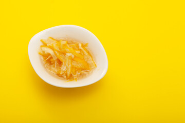 Lemon or Yuzu fruit slices with honey and sugar. Base ingredient for Yuja tea. Yellow background, top view, copy space