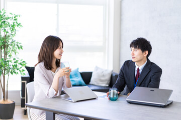 オフィスで楽しく話す男女
