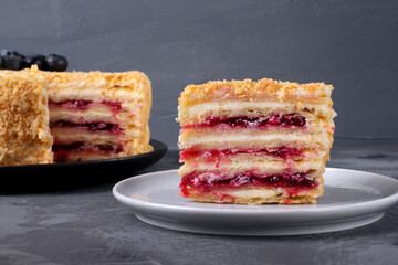 Chopped cake with buttercream and cowberry. Dessert portion is served on the ceramic plate