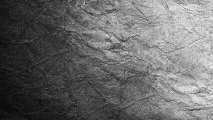 Black white grunge background. Gradient. Rough cracked rock surface texture. Close-up. Gray stone background with space for design.