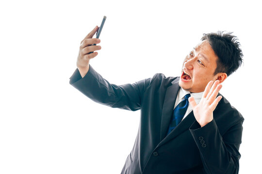自撮りをするスーツを着た中年男性