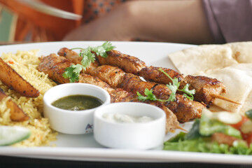 Seekh Kabab, Naan bread, and sauce on a plate 