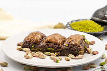 Chocolate baklava with pistachio on a white background. Traditional Mediterranean cuisine delicacies. Close-up Chocolate Baklava. local name cikolatali baklava